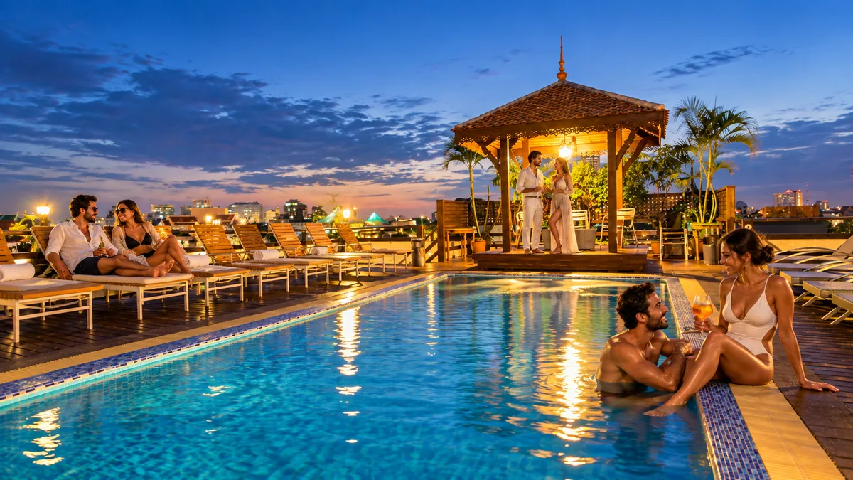 Adult couples relaxing beside the rooftop pool at Khaosan Palace Hotel at twilight